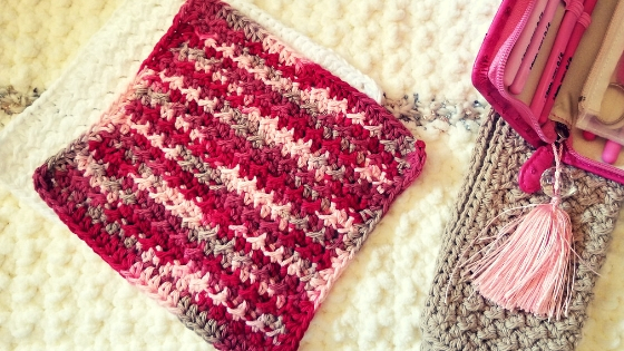 Crochet washcloth in cranberry pink and tan on white washcloth